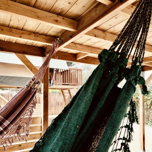 two hammocks hanging from a wooden ceiling at HolaCamp Sitges Garrofer in Sitges