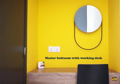a mirror on a yellow wall next to a desk at H2H - CY7 @ Majestic Ipoh in Ipoh