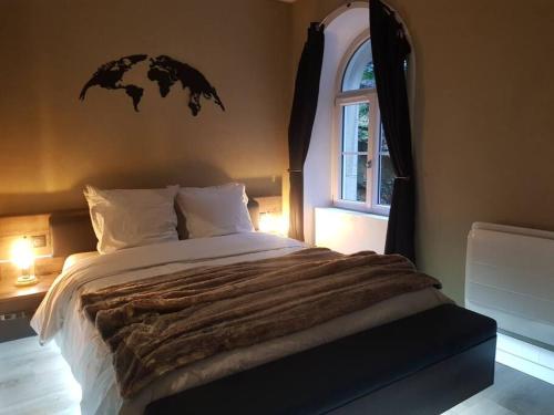 a bedroom with a large bed and a window at Appartement vue panoramique, sur les hauteurs de Lons in Lons-le-Saunier