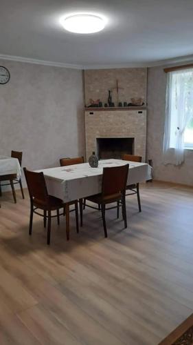 a living room with a table and chairs and a fireplace at Guest House House at the Forest სახლი ტყის პირას in Gordi