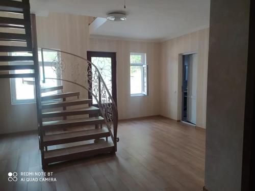 an empty room with a spiral staircase in a house at Guest House House at the Forest სახლი ტყის პირას in Gordi