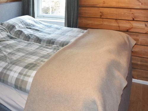 a bed with a blanket on it in a bedroom at 9 person holiday home in Geiranger-By Traum in Geiranger