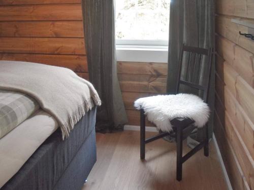 a wooden chair with a white pillow on it next to a window at 9 person holiday home in Geiranger-By Traum in Geiranger