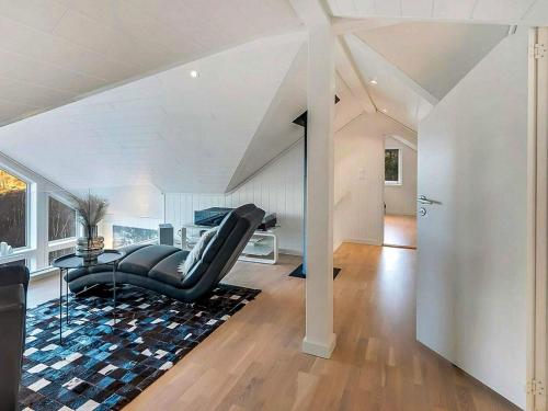 a living room with a black couch and a table at 8 person holiday home in lyngdal-By Traum in Lyngdal