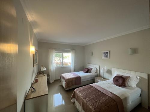 a hotel room with two beds and a window at Fairway 3 Appartement - Boavista Golf & Spa Resort in Lagos