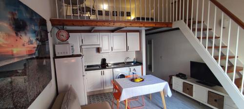 een kleine keuken met een tafel en een trap bij Marineda in El Médano