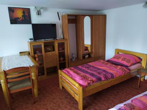 a bedroom with a bed and a table and a chair at Agroturystyka Jacnia in Jacnia