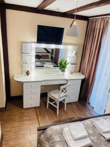 a desk with a mirror and a chair in a room at Fachwerk in Yaremche