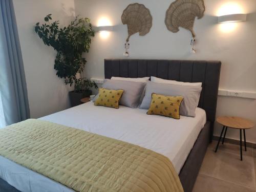 a bedroom with a large bed with yellow pillows at Coritos apartments Corfu in Kontokali