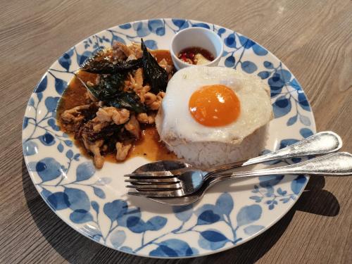 une plaque de nourriture avec un œuf et du riz dans l'établissement Capricorn Village - SHA Extra Plus, à Patong Beach