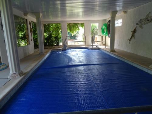 a swimming pool with blue water in a building at les Quatre Vents in Bragny-sur-Saône