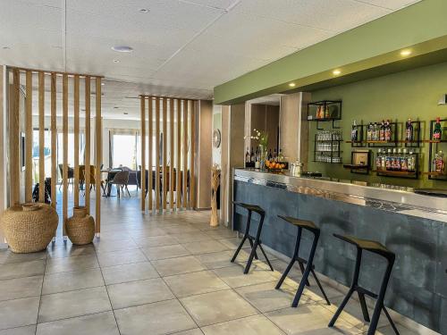 a restaurant with a bar with stools at Maria Stella in LʼÎle-Rousse