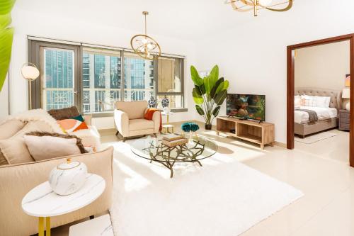 Una sala de estar con un sofá y un televisor. en Prime Retreats - 29 Emaar Boulevard Downtown Dubai, en Dubái
