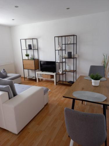 a living room with a white couch and a table at Ferienwohnung Salzmannhaus in Zschopau