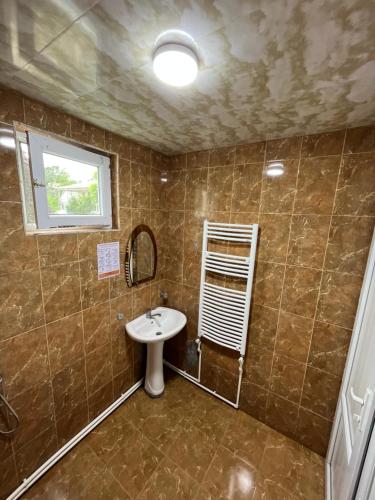 La salle de bains est pourvue d'un lavabo et d'un miroir. dans l'établissement Ureki Beach Apartment, à Ureki