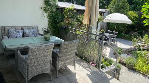 un patio con mesa, sillas y sombrilla en Marienburg en Lorsch