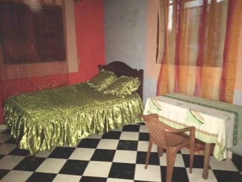 1 dormitorio con 1 cama, 1 mesa y 1 silla en TAMATAVE Chez Bien Aimée, en Toamasina