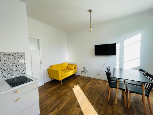 - un salon avec une table et un canapé jaune dans l'établissement Appartement Bonaparte centre ville d'Ajaccio, à Ajaccio