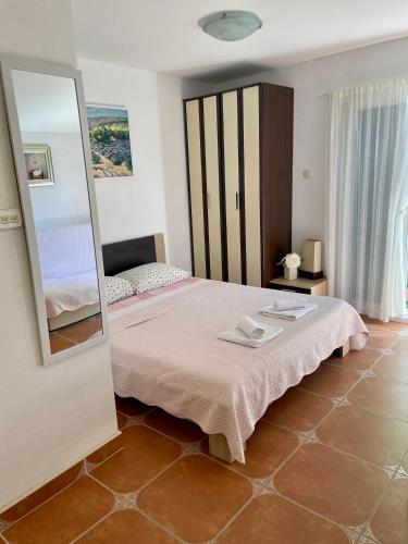 a bedroom with a large bed and a mirror at Studio Apartmani Kremić in Karlobag