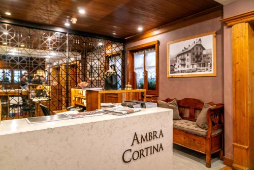 a shop with a counter and a chair in a room at Ambra Cortina Luxury&Fashion Hotel in Cortina dʼAmpezzo
