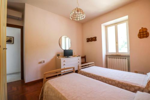 Coreglia LigureにあるMargherita Guest Houseのベッドルーム1室(ベッド2台、鏡付)