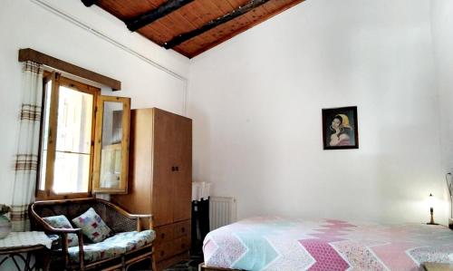 1 dormitorio con 1 cama, 1 silla y 1 ventana en Alexis country house in Georgioupoli, for 6 pers 4 km from the beach, en Khámbatha