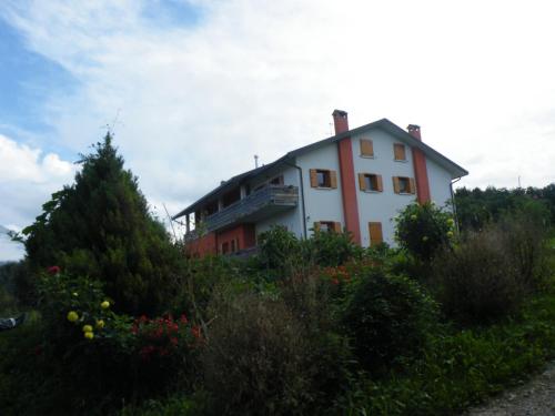 dom na zboczu wzgórza z roślinami w obiekcie Agriturismo Al Bachero w mieście Belluno