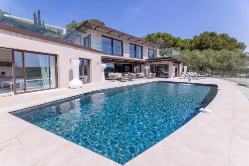 une piscine devant une maison dans l'établissement Villa Paulina MOUGINS, à Mougins