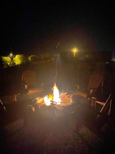 a fire pit at night with two benches at Cabana Guimarães in Rancho Queimado
