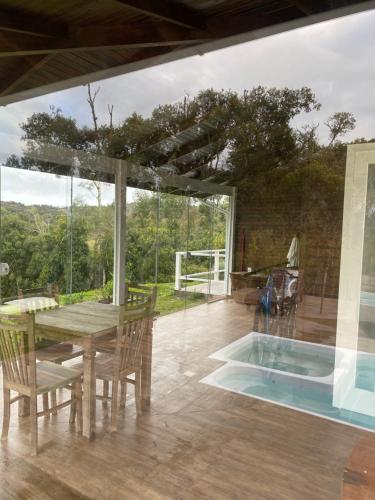 a patio with a table and chairs and a pool at Cabana Guimarães in Rancho Queimado