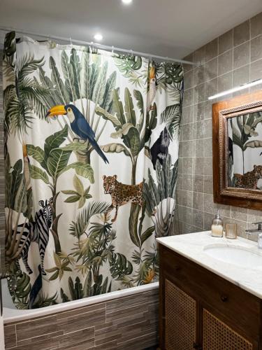 ein Bad mit einem Duschvorhang mit einem Vogel darauf in der Unterkunft La maison du Gardien - LE PRIEURÉ DU PREUX 