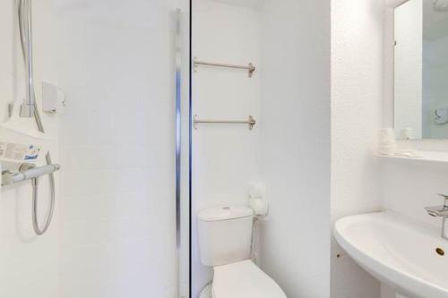 a bathroom with a shower and a toilet and a sink at Rev'Hotel in Port Leucate
