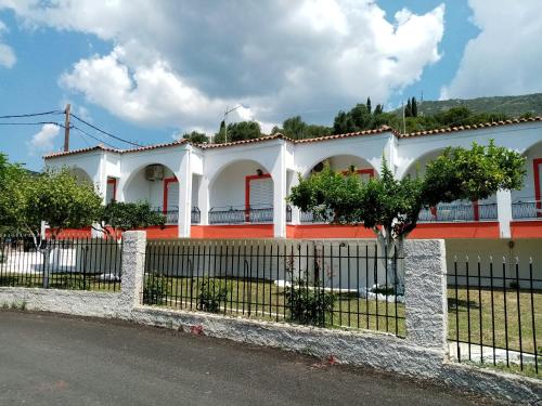 uma casa branca com uma cerca à frente. em Villa Nikitas em Parga