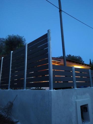a fence on top of a wall with a street light at Nikos' Home in Gastourion