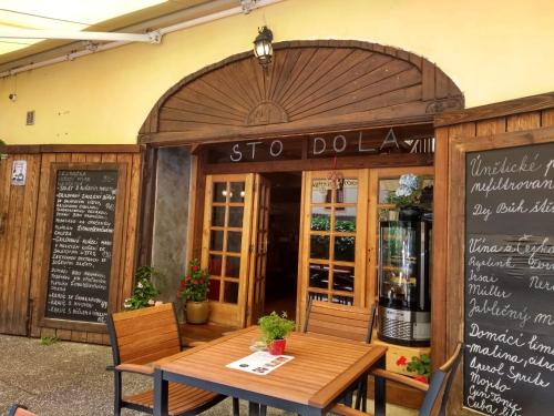 um restaurante com uma mesa de madeira em frente em Stodola-soukromý apartmán pro dva s venkovní vířivkou em Karlštejn