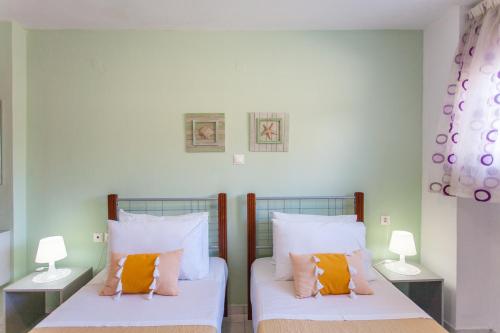 two beds in a room with two lamps at Joy apartment by the sea in Rethymno