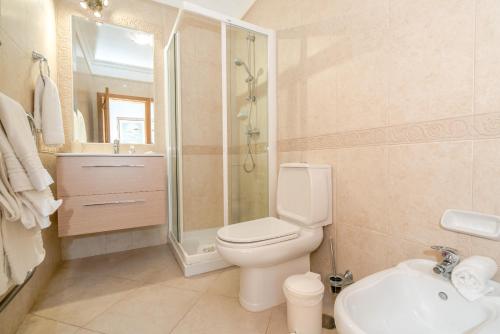 a bathroom with a toilet and a shower and a sink at Beautiful Villa on Boavista Golf Resort - Daily Service & Spa Access in Lagos