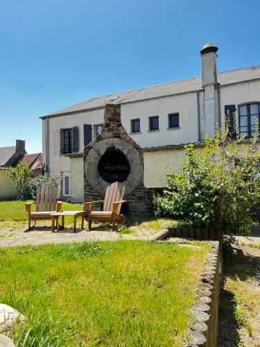 a building with two chairs and a brick oven at Contact Hotel Les Montois in Céaux