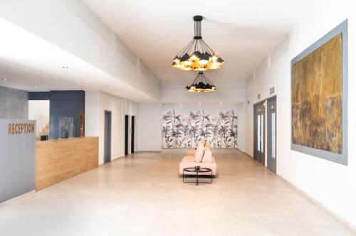 a living room with a couch and a chandelier at Galaxy Hotel in Porto Heli