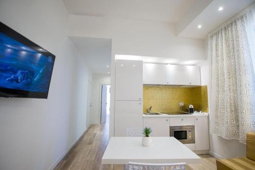 una cocina blanca con mesa en una habitación en Miami Suite, en Bellaria-Igea Marina