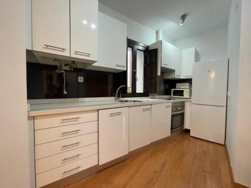 a kitchen with white cabinets and a white refrigerator at Palacio Santa Ursula in Toledo