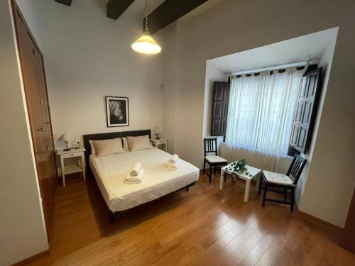 a bedroom with a bed and a table and chairs at Palacio Santa Ursula in Toledo