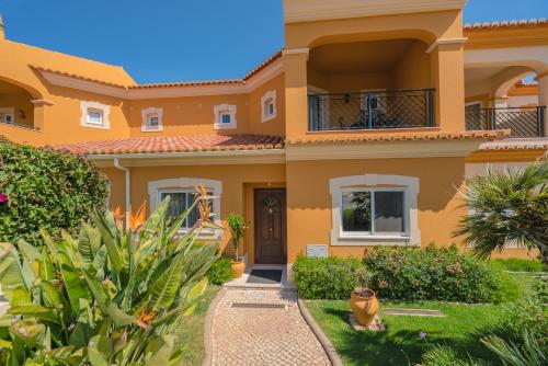 a villa with a garden in front of it at Beautiful Villa on Boavista Golf Resort - Daily Service & Spa Access in Lagos