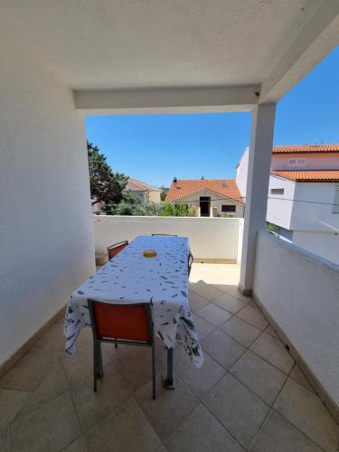 a table and a chair on a balcony at House MIRA in Barbat na Rabu