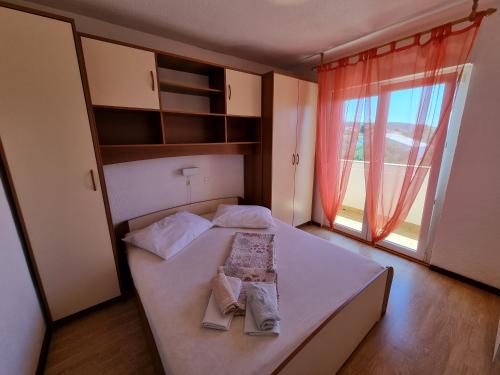 a bedroom with a bed and a large window at House MIRA in Barbat na Rabu