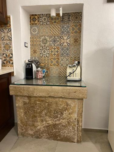 a kitchen with a stone counter top with a tile wall at Casale Montereale in Corato