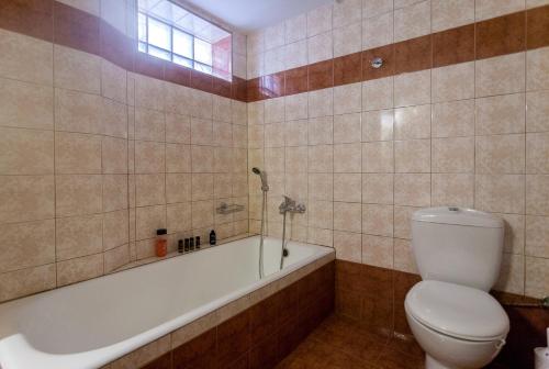 a bathroom with a toilet and a bath tub at Joy apartment by the sea in Rethymno