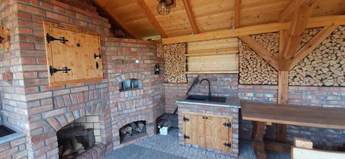 ceglana kuchnia z ceglanym kominkiem w domu w obiekcie Magico Posto w mieście Wierzchucino