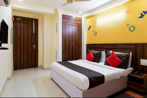 a bedroom with a large bed with red pillows at Ishtara Auberge in New Delhi