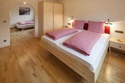 a bedroom with a large bed with red and white pillows at Alpe Oberstdorf in Oberstdorf